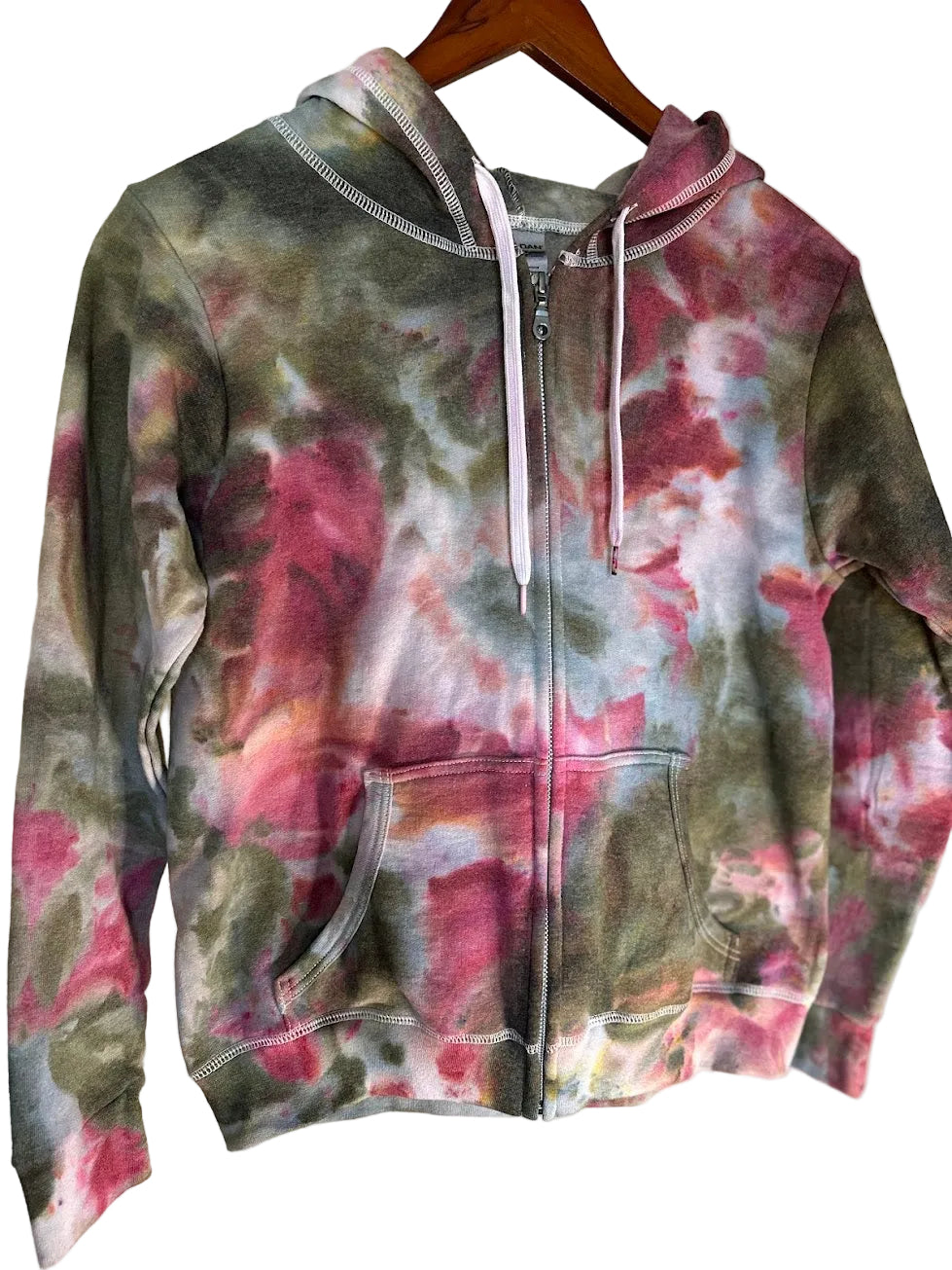 Tie-dye hoodie with pink, green, and gray patterns on a beige background
